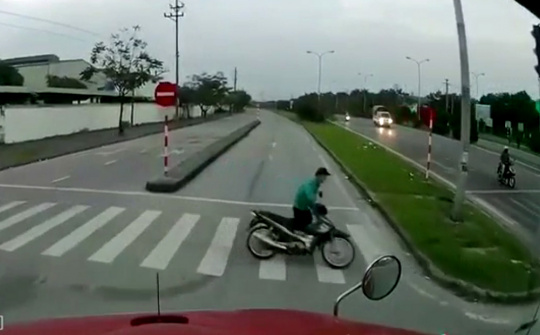 Quẳng xe máy chạy thoát thân trước đầu container