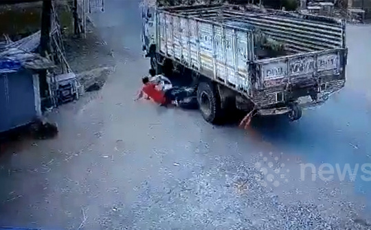 Hai quái xế đầu trần khoe tốc độ mất hút trong gầm xe tải