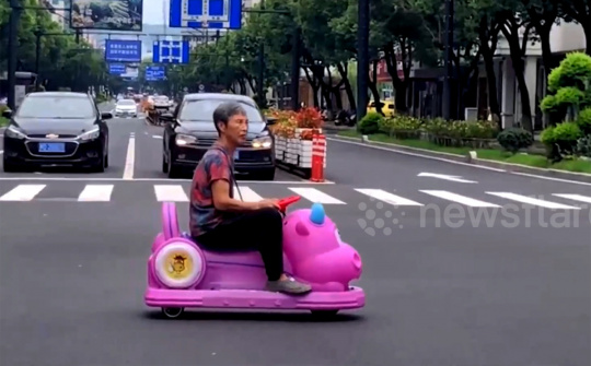 Người phụ nữ nổi nhất phố, lái ô tô đồ chơi màu hồng đi dạo