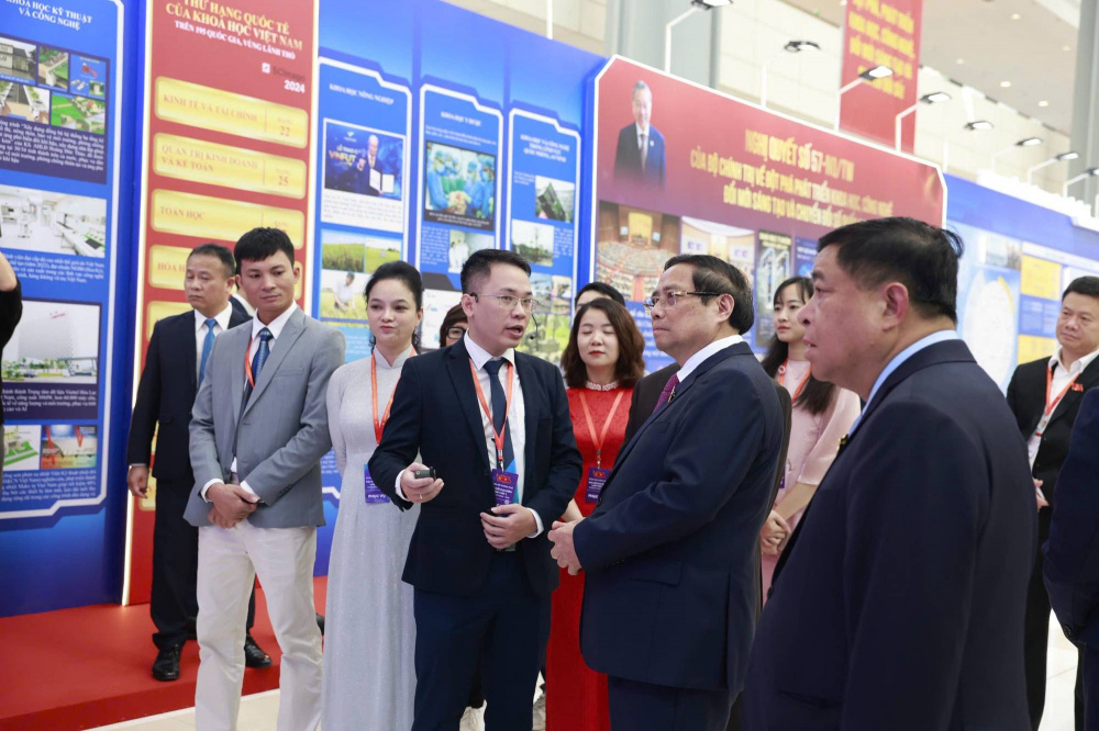 Thủ tướng Phạm Minh Chính và các đại biểu nghe giới thiệu về triển lãm ảnh thành tựu, kết quả nhiệm kỳ 2021-2025 của các đảng ủy trực thuộc nhân dịp Đại hội - Ảnh: VGP