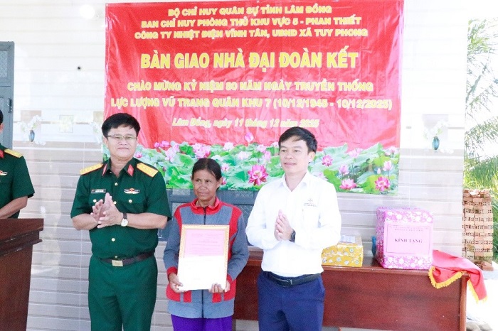 Đại diện Lãnh đạo Công ty Nhiệt điện Vĩnh Tân, Ban Chỉ huy Phòng thủ Khu vực 5 và chính quyền địa phương trao bảng tượng trưng “Nhà Đại đoàn kết” cho gia đình bà Hoàng Thị Song