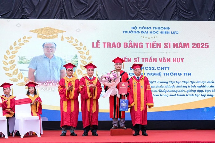 PGS.TS Vũ Đình Ngọ - Chủ tịch Hội đồng trường (thứ 2 từ trái sang phải) và PGS.TS Đinh Văn Châu - Hiệu trưởng Trường Đại học Điện lực (bên phải ngoài cùng) trao bằng tốt nghiệp và chúc mừng tân tiến sĩ.