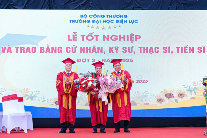 PGS.TS Vũ Đình Ngọ - Chủ tịch Hội đồng trường (bên trái ngoài cùng) và PGS.TS Đinh Văn Châu - Hiệu trưởng Trường Đại học Điện lực (bên phải ngoài cùng) tặng hoa chúc mừng TS. Dương Trung Kiên nhận công tác mới.