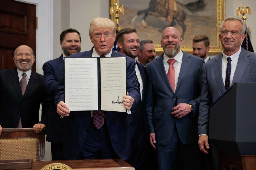 Tổng thống Mỹ Donald Trump cùng sắc lệnh hành pháp đã ký vào ngày 31.7 - Ảnh: AFP.