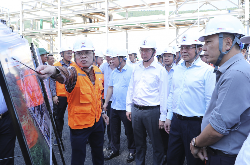 Uỷ viên Ban chấp hành Trung ương Đảng, Bộ trưởng Bộ Công Thương Lê Mạnh Hùng (thứ hai từ phải sang, hàng đầu), Chủ tịch UBND tỉnh Quảng Trị Bùi Hoàng Phương (thứ ba từ phải sang, hàng đầu) và Chủ tịch HĐTV EVN Đặng Hoàng An (ngoài cùng bên phải, hàng đầu) nghe Giám đốc Ban Quản lý Dự án Điện 2 Đỗ Thành Tài (áo cam) báo cáo về tình hình triển khai các dự án tại Trung tâm Điện lực Quảng Trạch