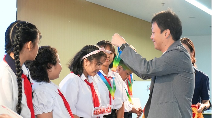 Đại diện công ty Acecook Việt Nam trao quà và huy chương cho các em tham gia chương trình “Chuyến đi hạnh phúc 2026”.